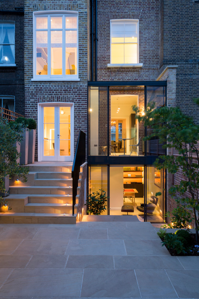 Inspiration for a medium sized contemporary brick house exterior in London with three floors.