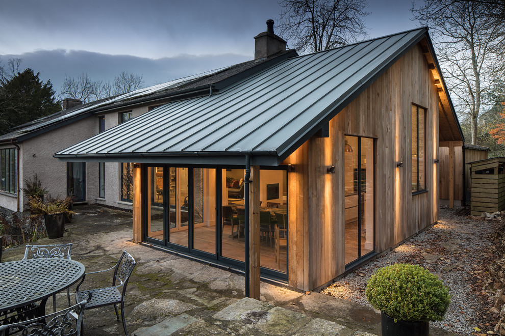 Diseño de fachada de casa bifamiliar marrón contemporánea grande de una planta con revestimiento de madera, tejado a dos aguas y tejado de metal