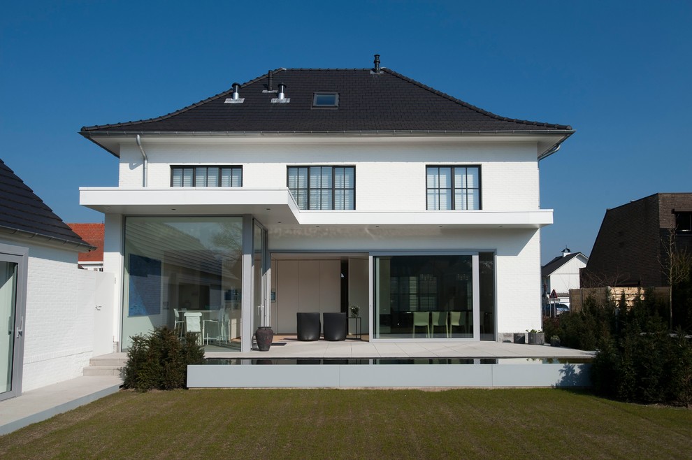 White contemporary two floor house exterior in Other with a mansard roof.