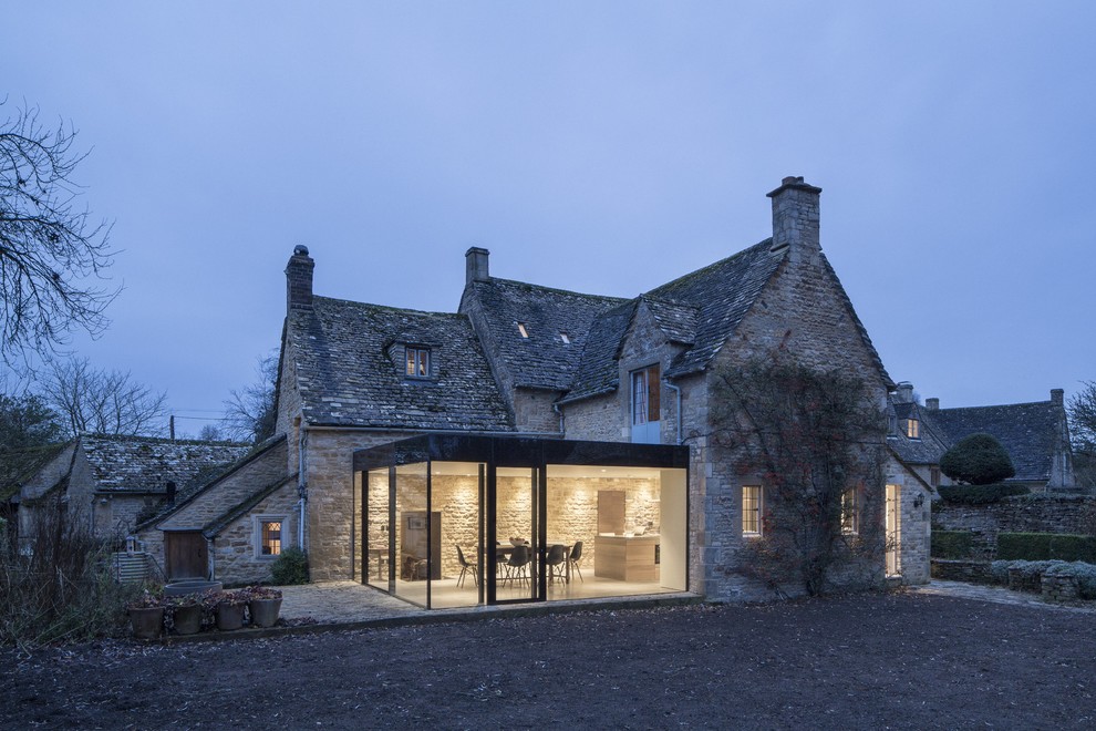 Exemple d'une façade de maison beige nature en brique de taille moyenne et à deux étages et plus avec un toit à quatre pans.