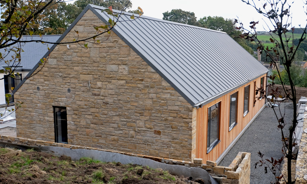 Réalisation d'une grande façade de maison design de plain-pied avec un revêtement mixte, un toit à deux pans et un toit en métal.