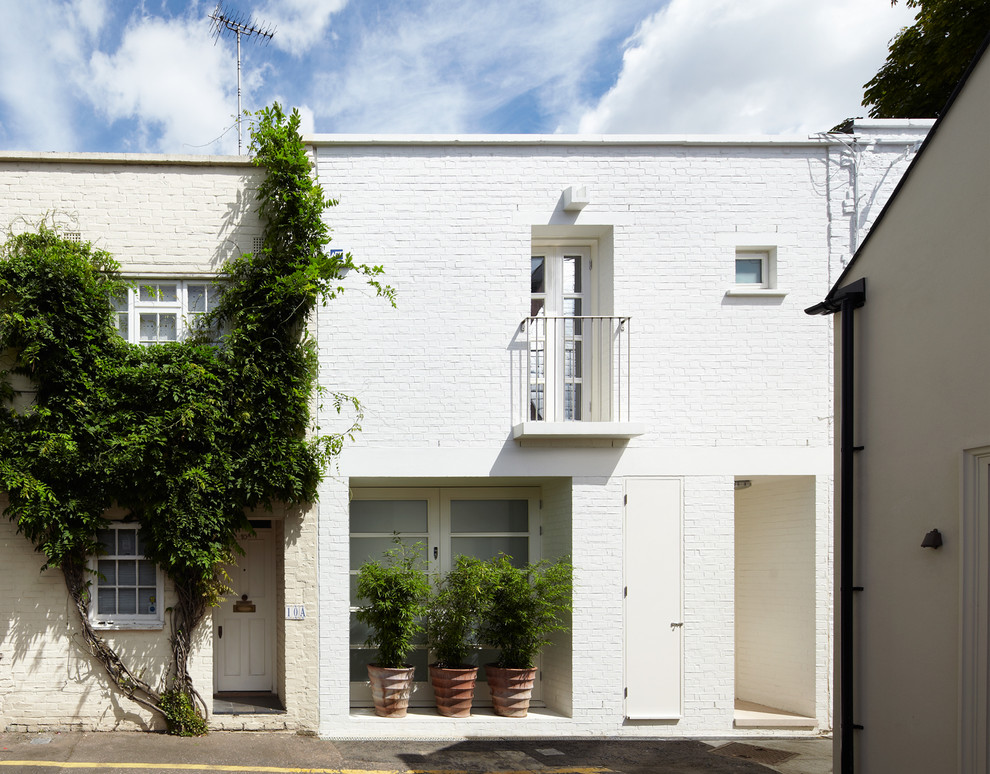 Imagen de fachada blanca contemporánea pequeña de dos plantas con revestimiento de ladrillo y tejado plano