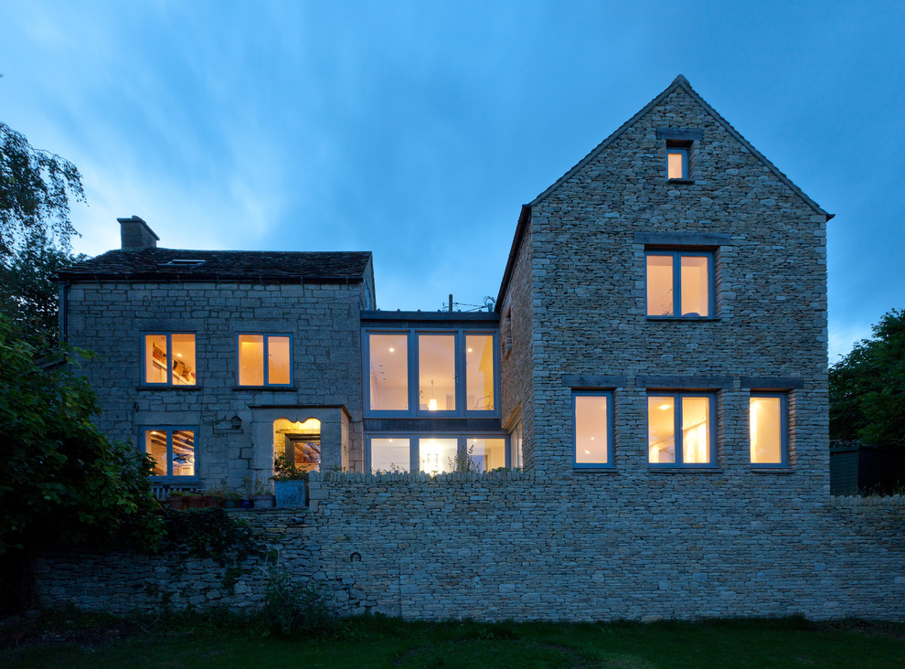 Large rural two floor house exterior in Gloucestershire with stone cladding and a pitched roof.
