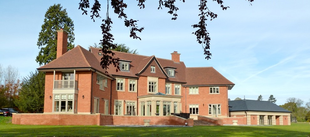 This is an example of an expansive and red traditional brick house exterior in West Midlands with three floors and a pitched roof.