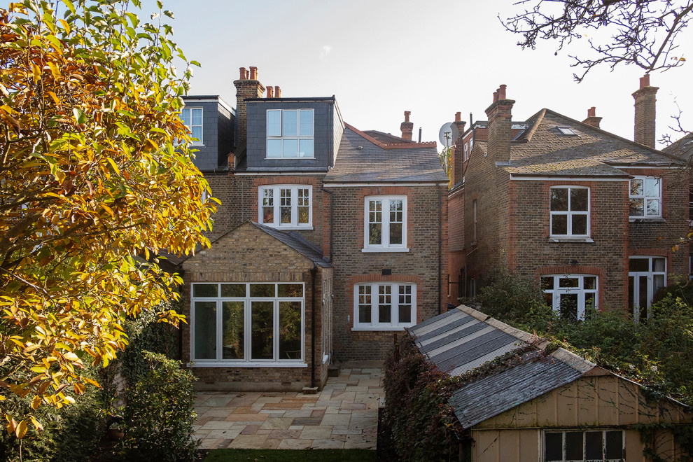 Photo of a medium sized traditional two floor brick semi-detached house in London with a hip roof and a shingle roof.