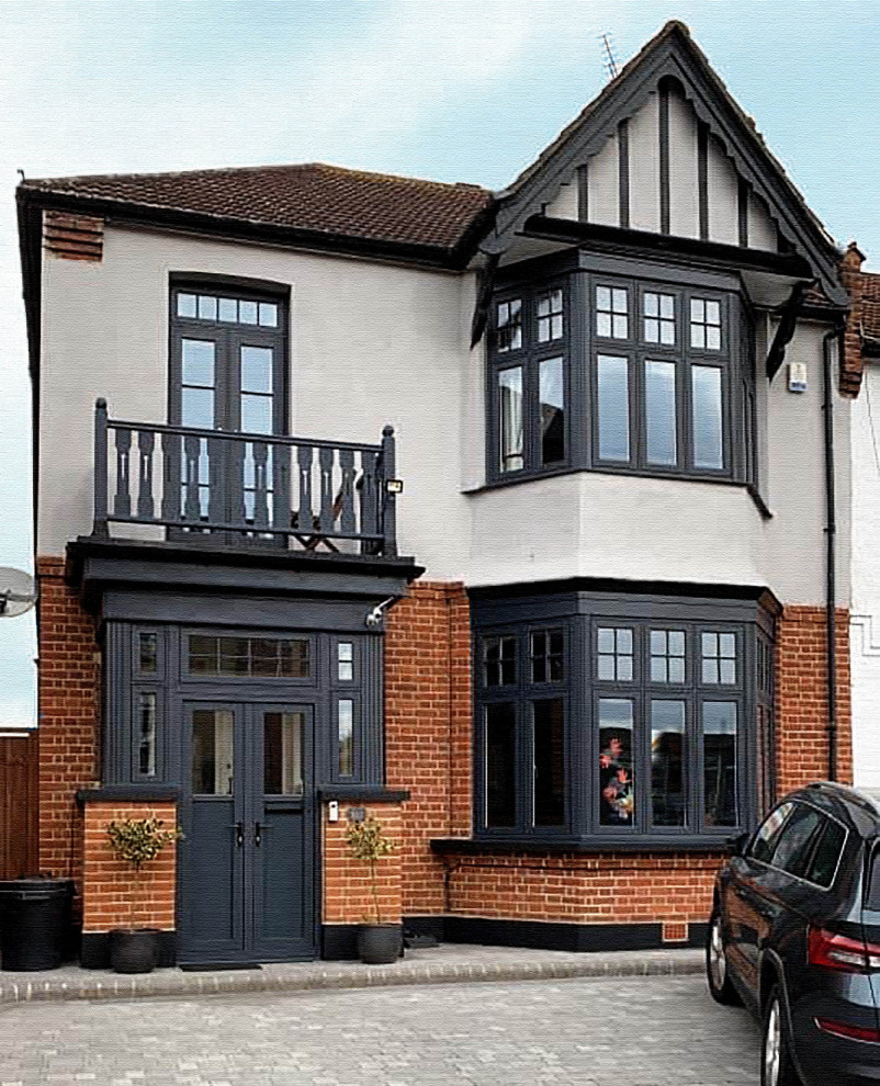 Large and gey contemporary two floor brick semi-detached house in London with a pitched roof and a shingle roof.