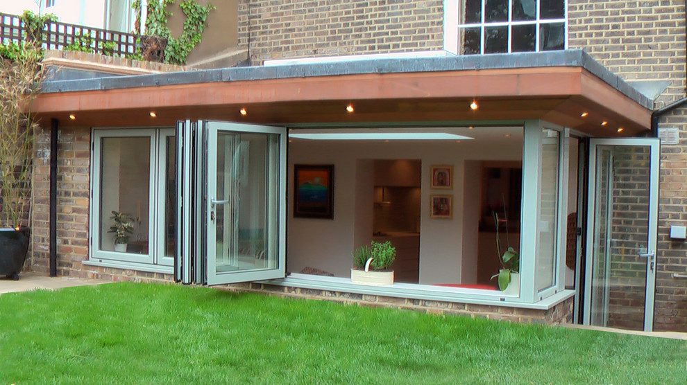 Cette image montre une façade de maison marron design en brique de taille moyenne et à un étage avec un toit à deux pans.