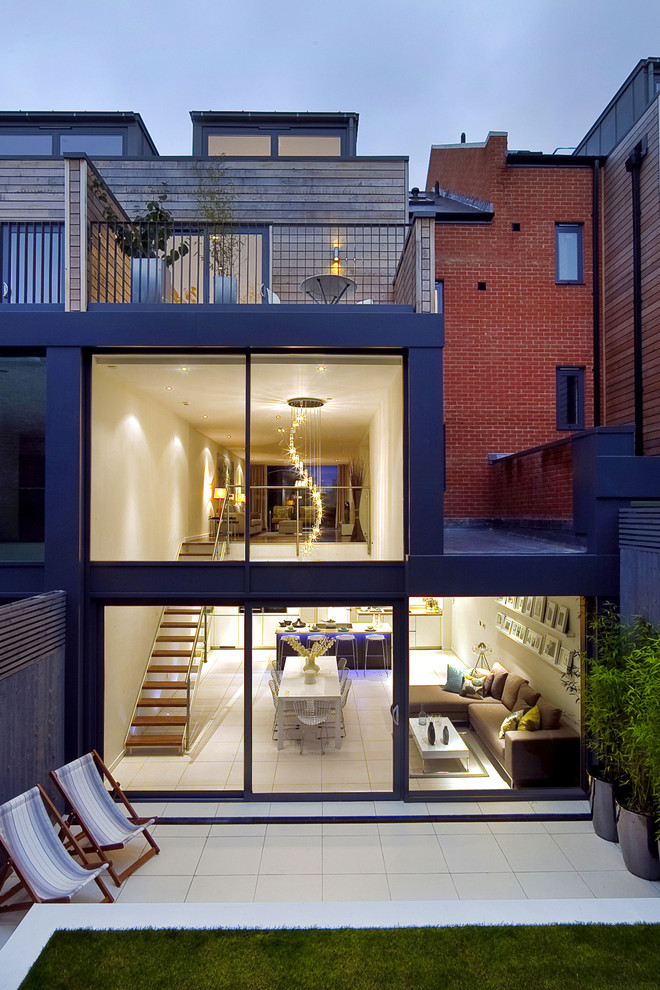 Immagine della facciata di una casa a schiera moderna a tre piani con rivestimento in vetro