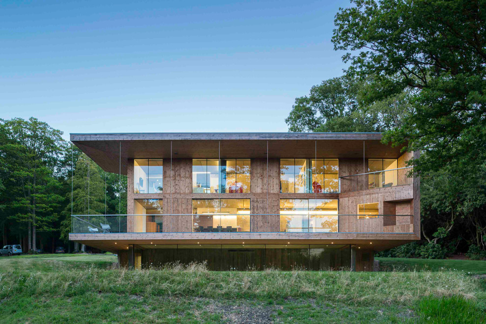 Aménagement d'une grande façade de maison marron contemporaine en bois à deux étages et plus avec un toit plat.