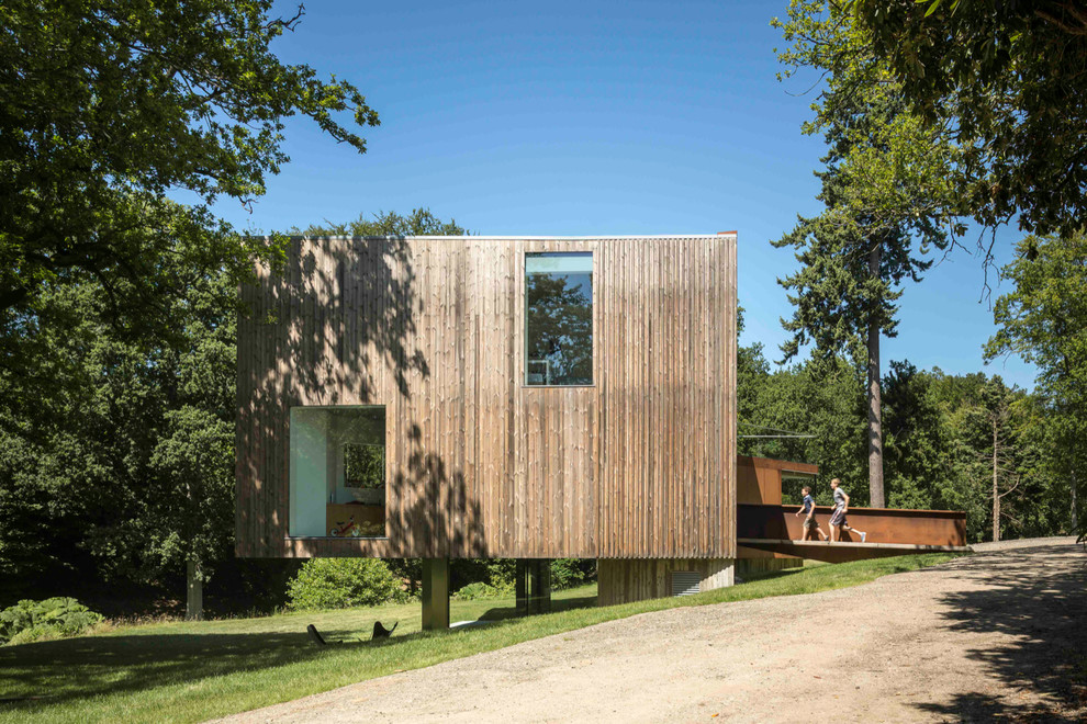 Cette photo montre une grande façade de maison marron tendance en bois à deux étages et plus avec un toit plat.