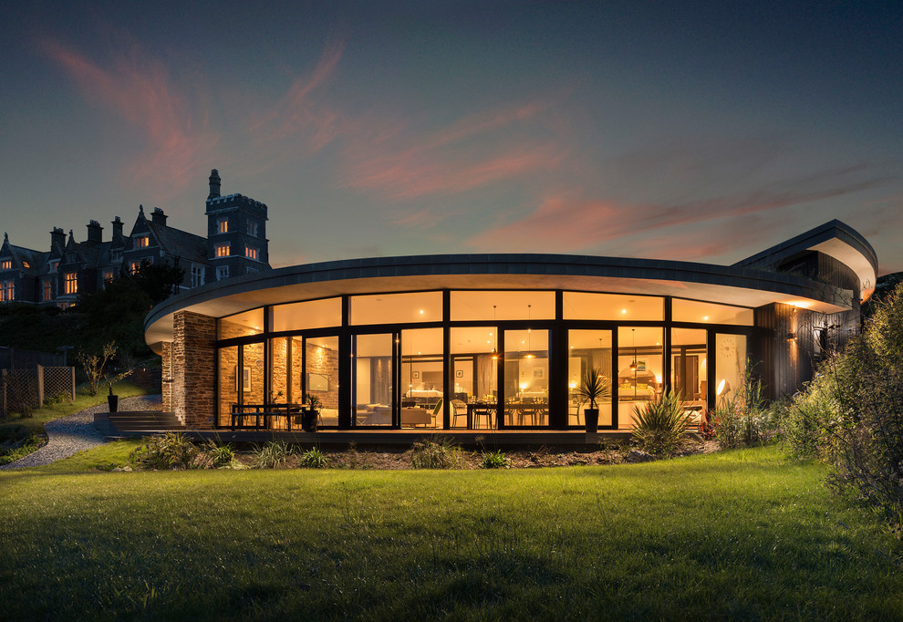 Стильный дизайн: большой частный загородный дом в современном стиле с разными уровнями, облицовкой из камня и зеленой крышей - последний тренд