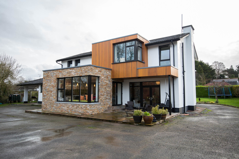 Diseño de fachada de casa multicolor contemporánea de dos plantas con revestimientos combinados y tejado de teja de barro