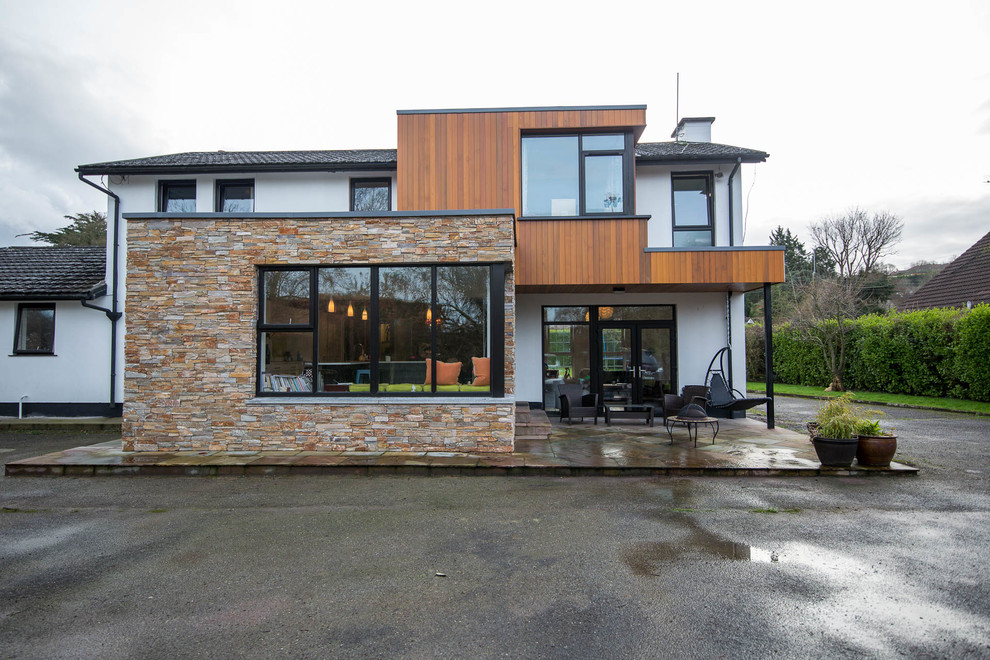 Idées déco pour une façade de maison multicolore contemporaine à un étage avec un revêtement mixte et un toit en tuile.