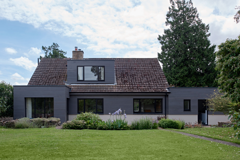 Idées déco pour une façade de maison grise contemporaine en bois de taille moyenne et à un étage avec un toit à deux pans.