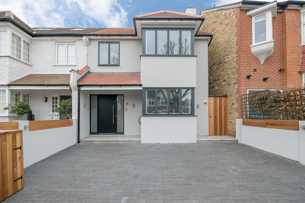 Photo of a medium sized modern render semi-detached house in London with three floors, a flat roof and a mixed material roof.