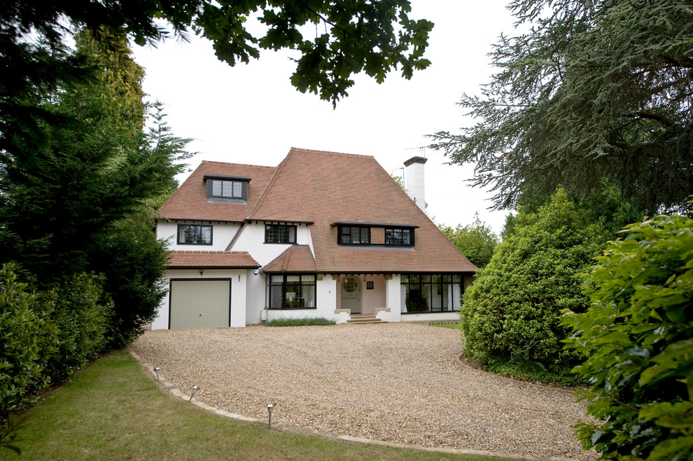 Inspiration for a large and white classic render detached house in Surrey with three floors, a hip roof and a shingle roof.