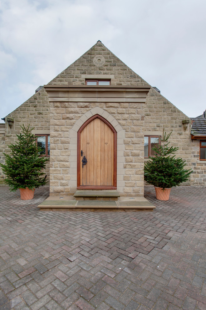 This is an example of a medium sized traditional two floor house exterior in Other with stone cladding.