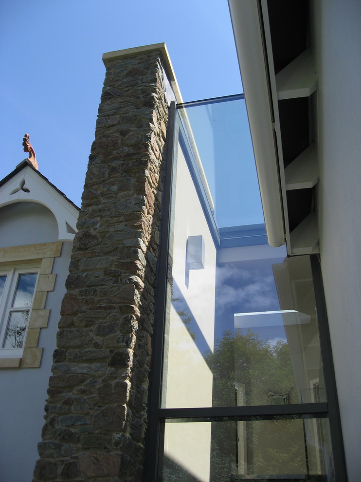 Cette photo montre une petite façade de maison moderne en verre avec un toit à deux pans.