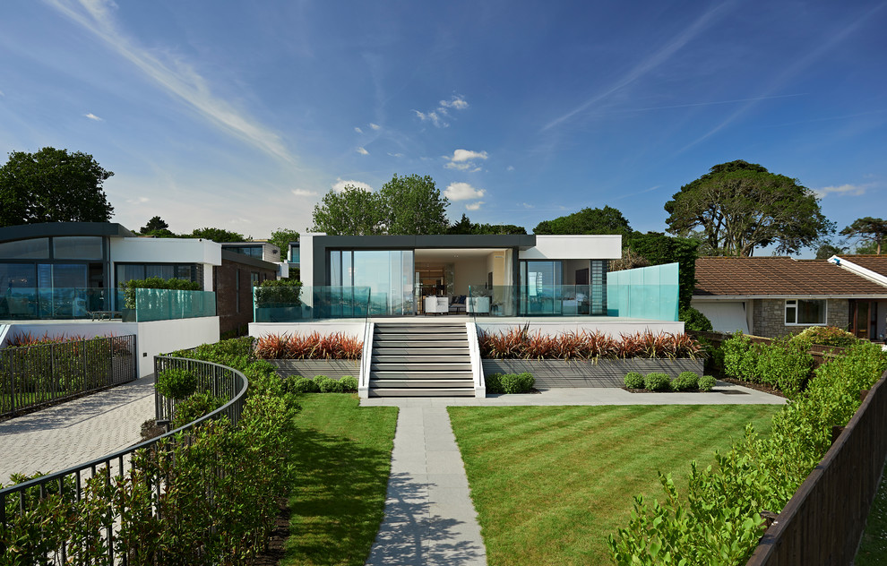 Idee per la facciata di una casa bianca contemporanea con rivestimenti misti e tetto piano