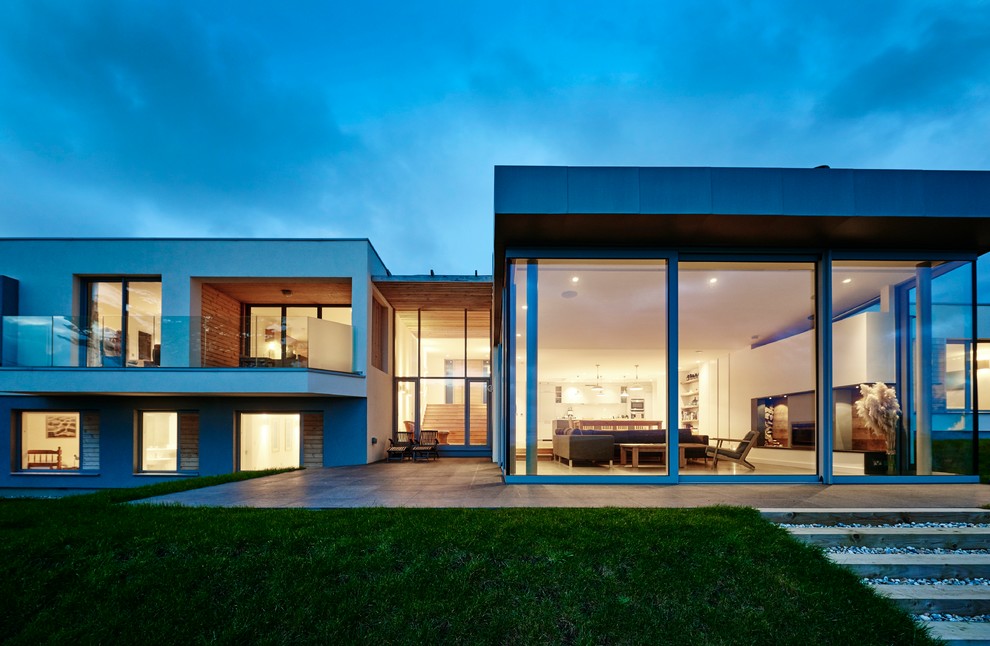 Großes, Zweistöckiges Modernes Haus mit Putzfassade, weißer Fassadenfarbe und Flachdach in Devon