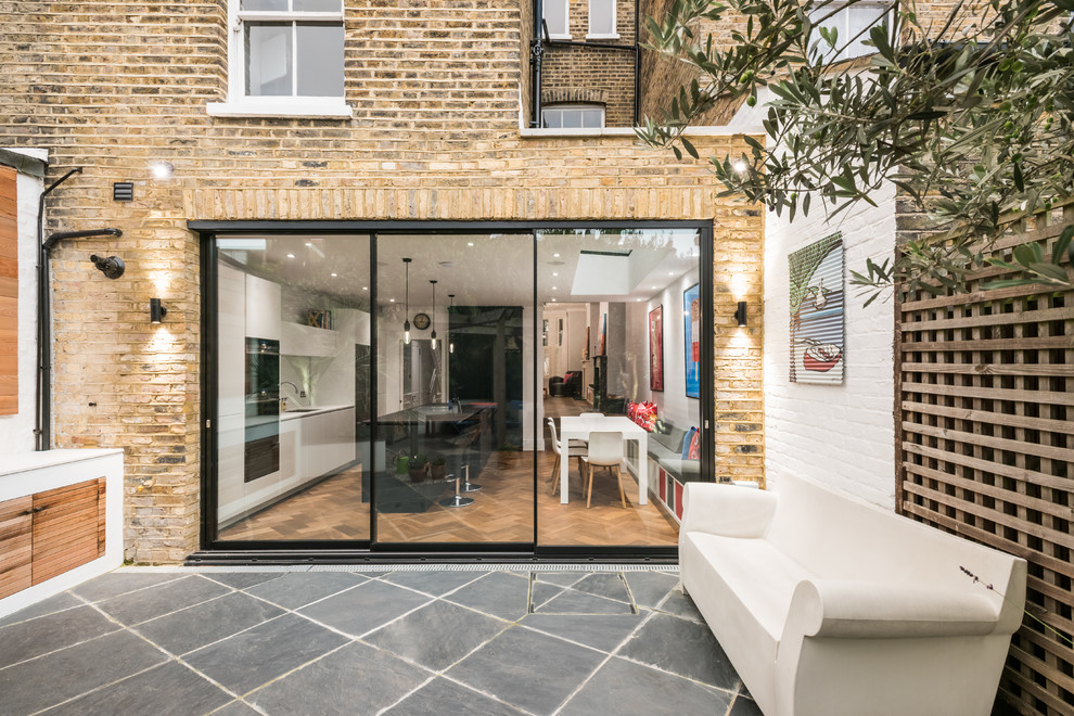 Inspiration for a large contemporary yellow three-story brick exterior home remodel in London