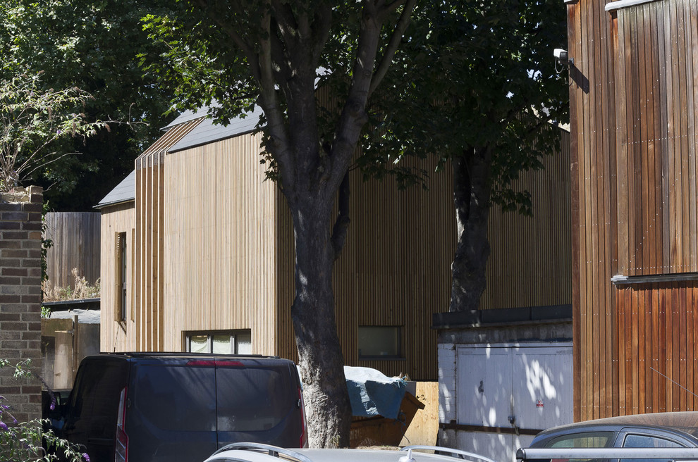 Foto de fachada minimalista de dos plantas con revestimiento de madera y tejado a dos aguas