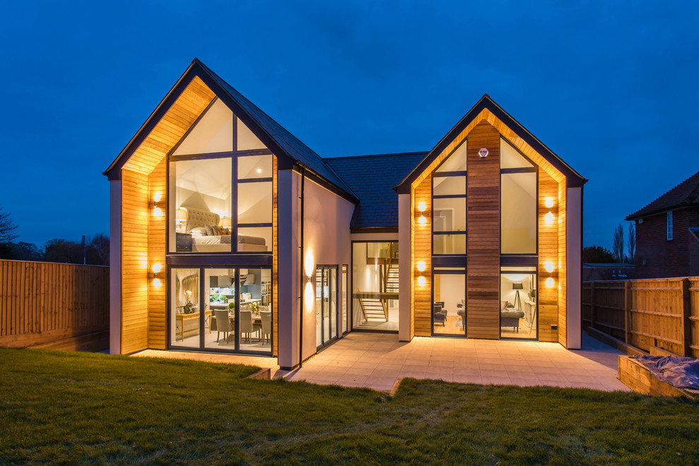 This is an example of a large contemporary two floor detached house in Buckinghamshire with wood cladding and a pitched roof.