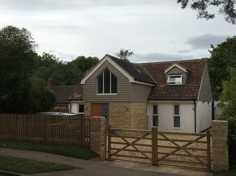 This is an example of a multi-coloured rural two floor house exterior in Other with mixed cladding, a pitched roof and a tiled roof.