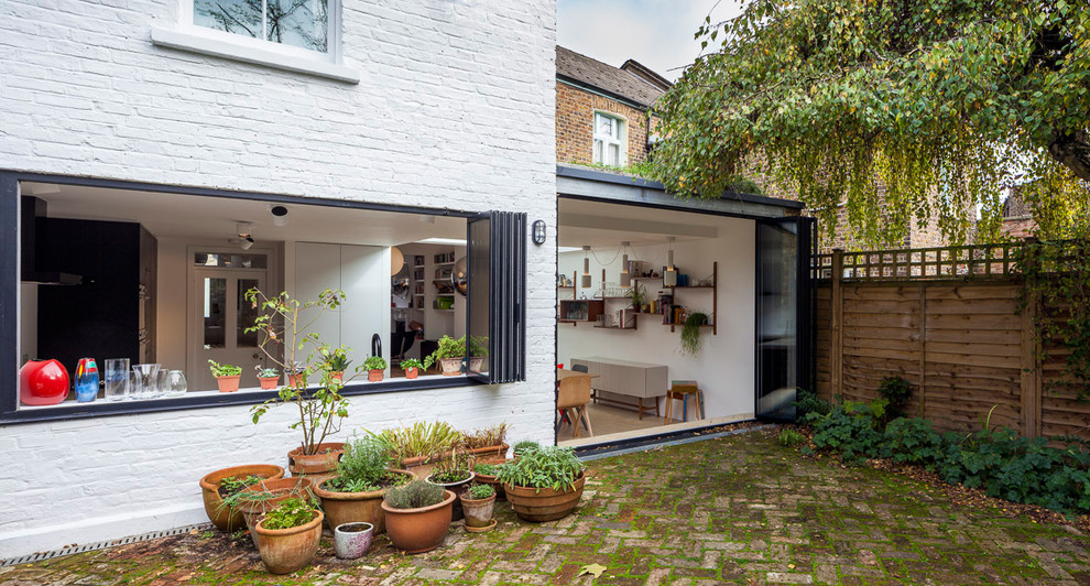 Design ideas for a medium sized and gey modern terraced house in London with three floors, metal cladding, a flat roof and a mixed material roof.