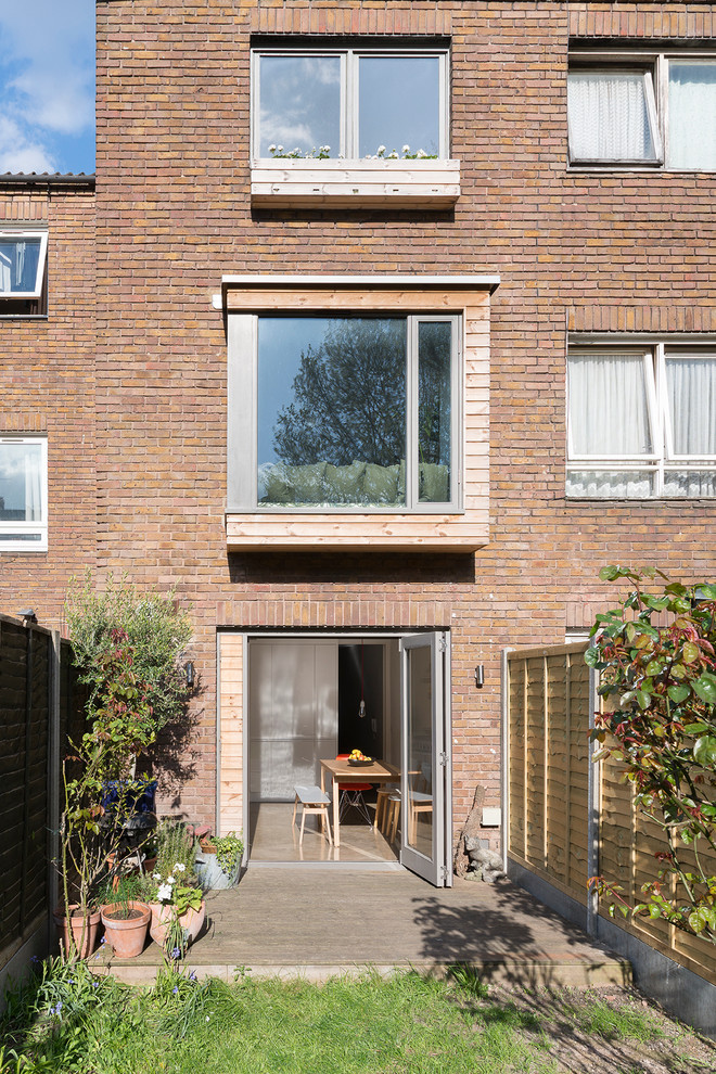 Inspiration for a contemporary brick house exterior in London with three floors.