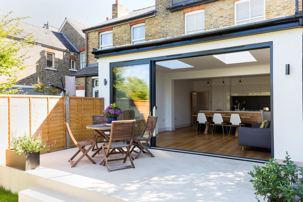 Large and red contemporary bungalow render and rear extension in London with a flat roof.