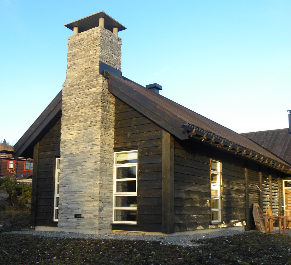 Cette photo montre une façade de maison noire tendance en pierre de taille moyenne et à un étage avec un toit à deux pans.