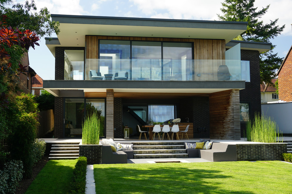 Ejemplo de fachada de casa multicolor actual grande de dos plantas con revestimientos combinados y tejado plano