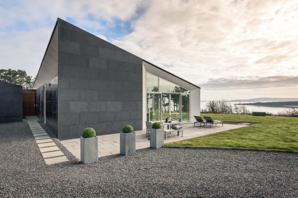 Mittelgroßes, Einstöckiges Modernes Einfamilienhaus mit Steinfassade, schwarzer Fassadenfarbe und Flachdach in Cork