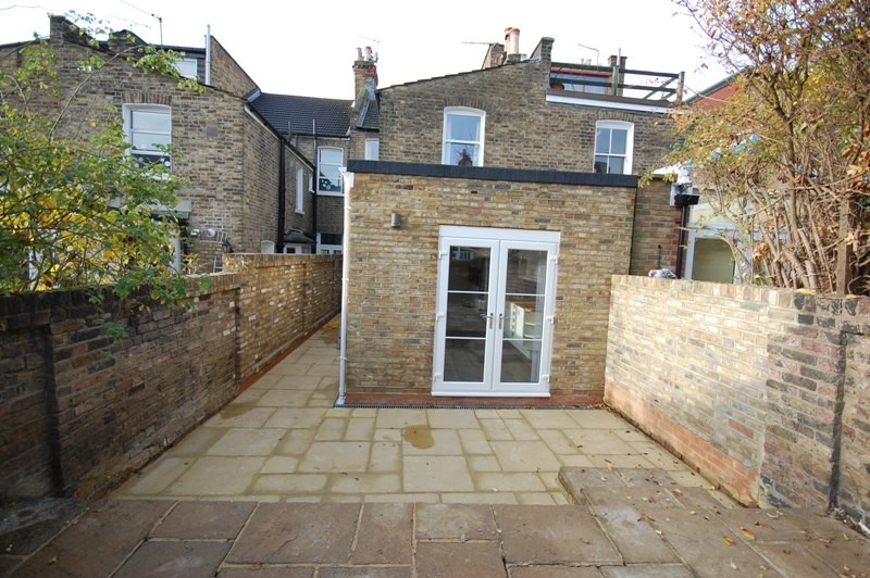 Photo of a medium sized and beige classic two floor brick house exterior in London with a flat roof.