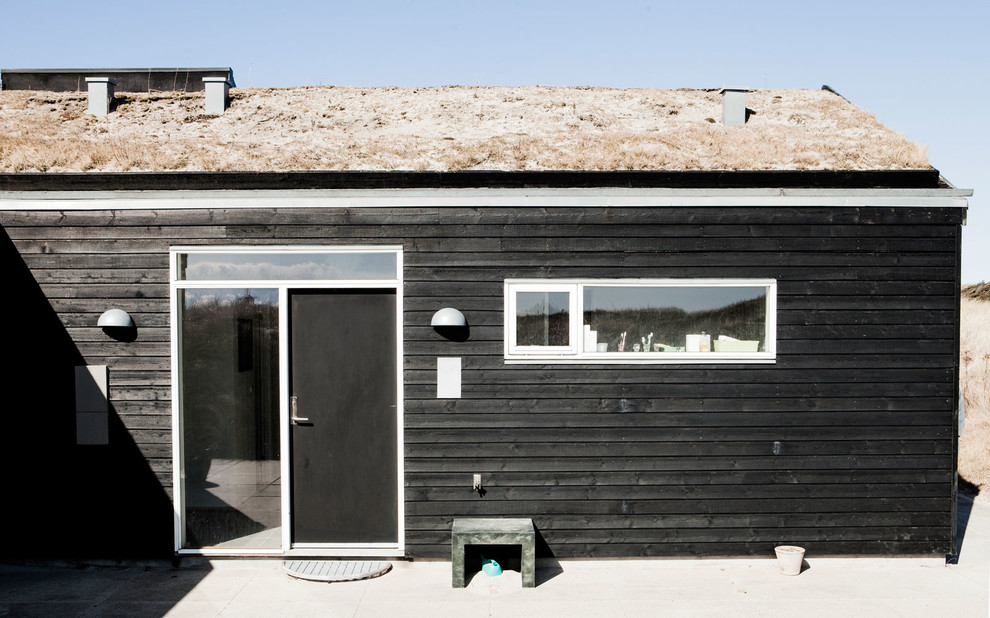 Foto della facciata di una casa nera scandinava di medie dimensioni con rivestimento in legno e tetto a capanna