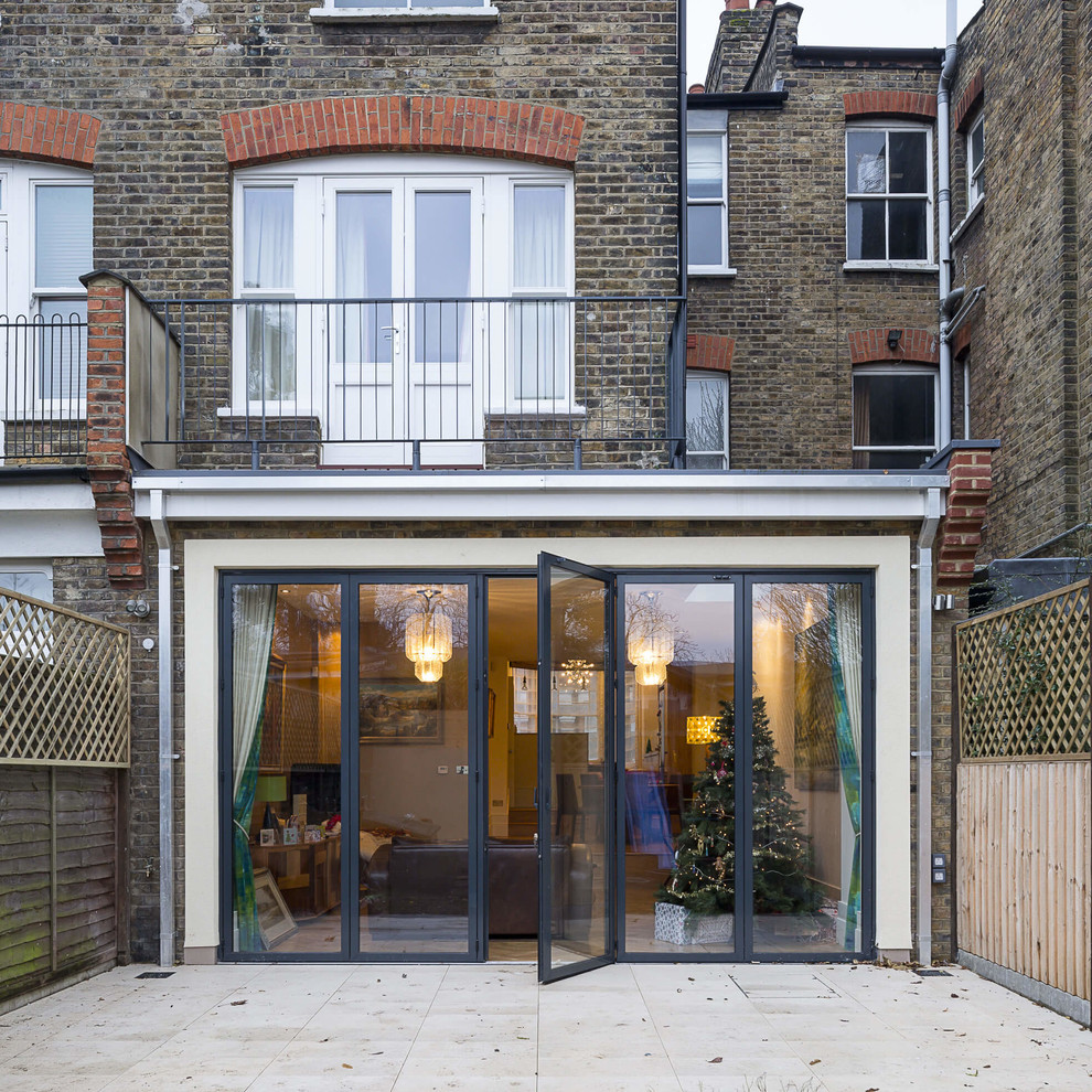 Réalisation d'une façade de maison design de taille moyenne avec un revêtement mixte et un toit plat.