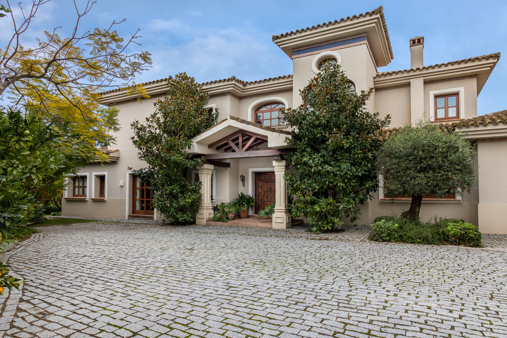 Großes, Zweistöckiges Klassisches Haus mit Mix-Fassade, beiger Fassadenfarbe und Walmdach in Sonstige