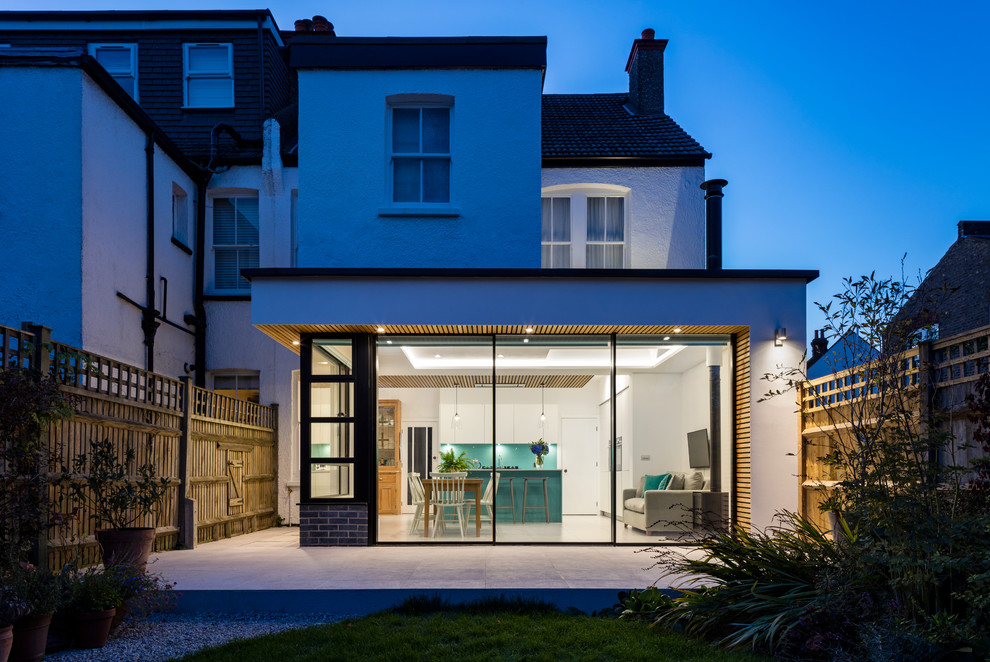 Modelo de fachada de casa bifamiliar blanca contemporánea con revestimiento de estuco y tejado plano