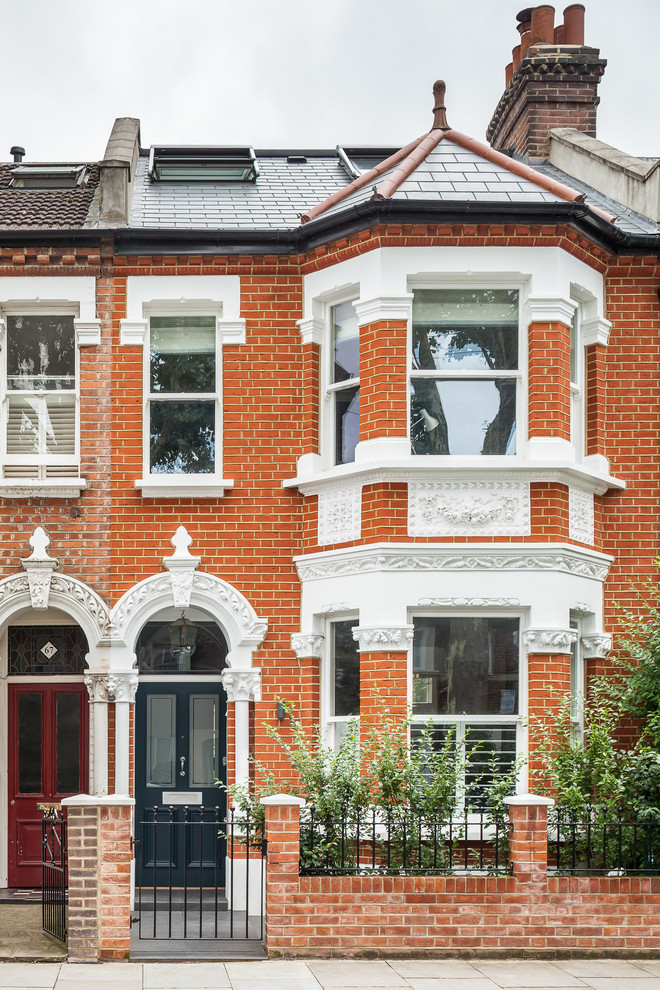 Design ideas for a medium sized and red traditional brick terraced house in London with three floors and a pitched roof.