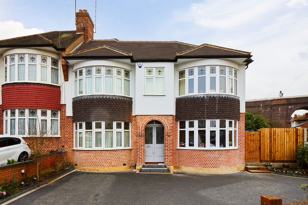 This is an example of a white traditional two floor semi-detached house in London with a pitched roof and a tiled roof.