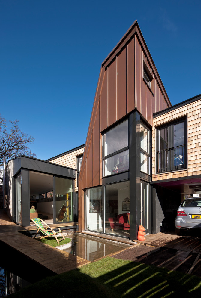 Idéer för att renovera ett funkis brunt hus, med blandad fasad och pulpettak