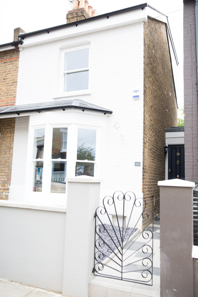 This is an example of a medium sized and multi-coloured modern brick semi-detached house in London with three floors, a flat roof and a tiled roof.
