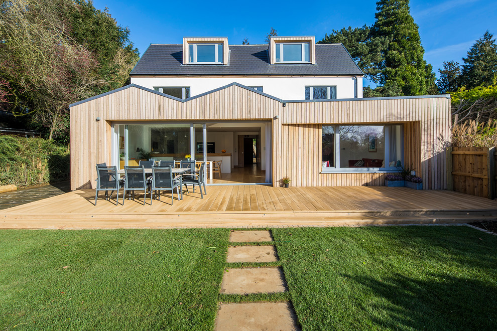 Cette photo montre une façade de maison multicolore tendance en bois et planches et couvre-joints de taille moyenne et à deux étages et plus avec un toit à deux pans, un toit mixte et un toit gris.