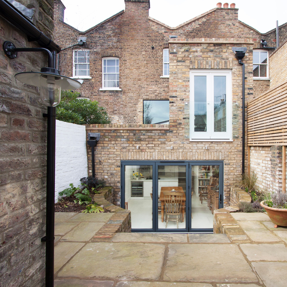 Inspiration for a medium sized classic brick house exterior in London with three floors.