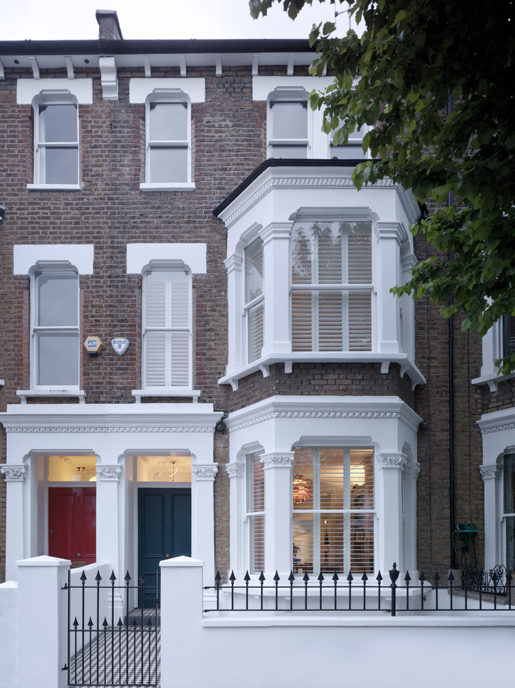 Medium sized and brown contemporary terraced house in London with three floors, a pitched roof and a tiled roof.
