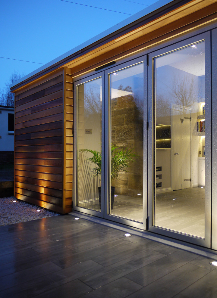 Large contemporary three-story wood flat roof idea in Edinburgh