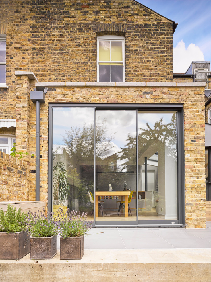 Inspiration for a mid-sized contemporary beige brick exterior home remodel in London