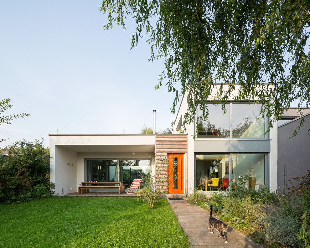 Imagen de fachada blanca minimalista de tamaño medio a niveles con revestimientos combinados y tejado plano