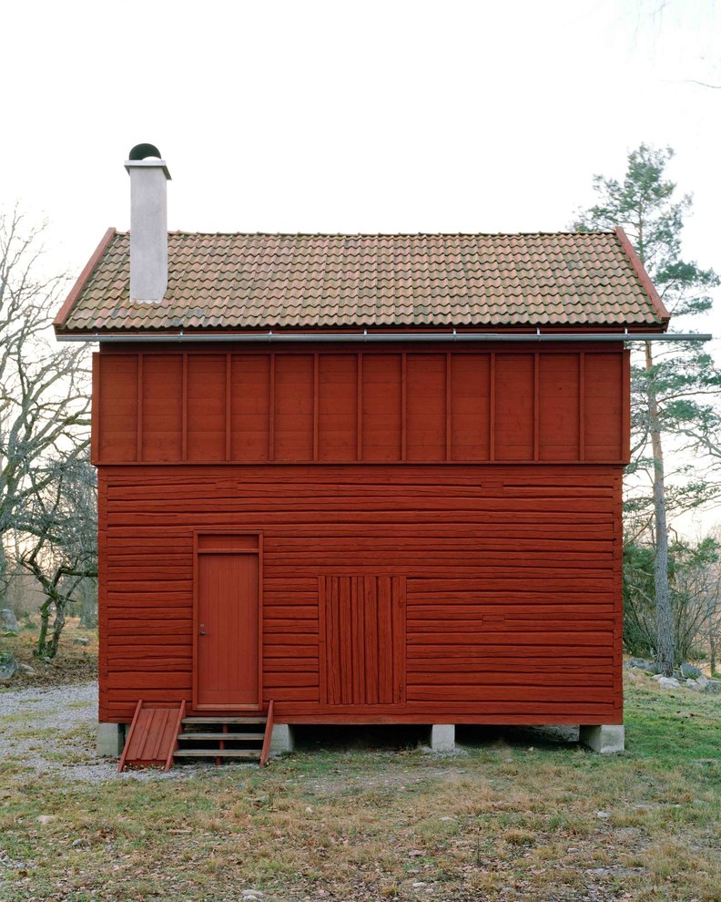 Modelo de fachada roja escandinava pequeña de dos plantas con revestimiento de madera y tejado a dos aguas